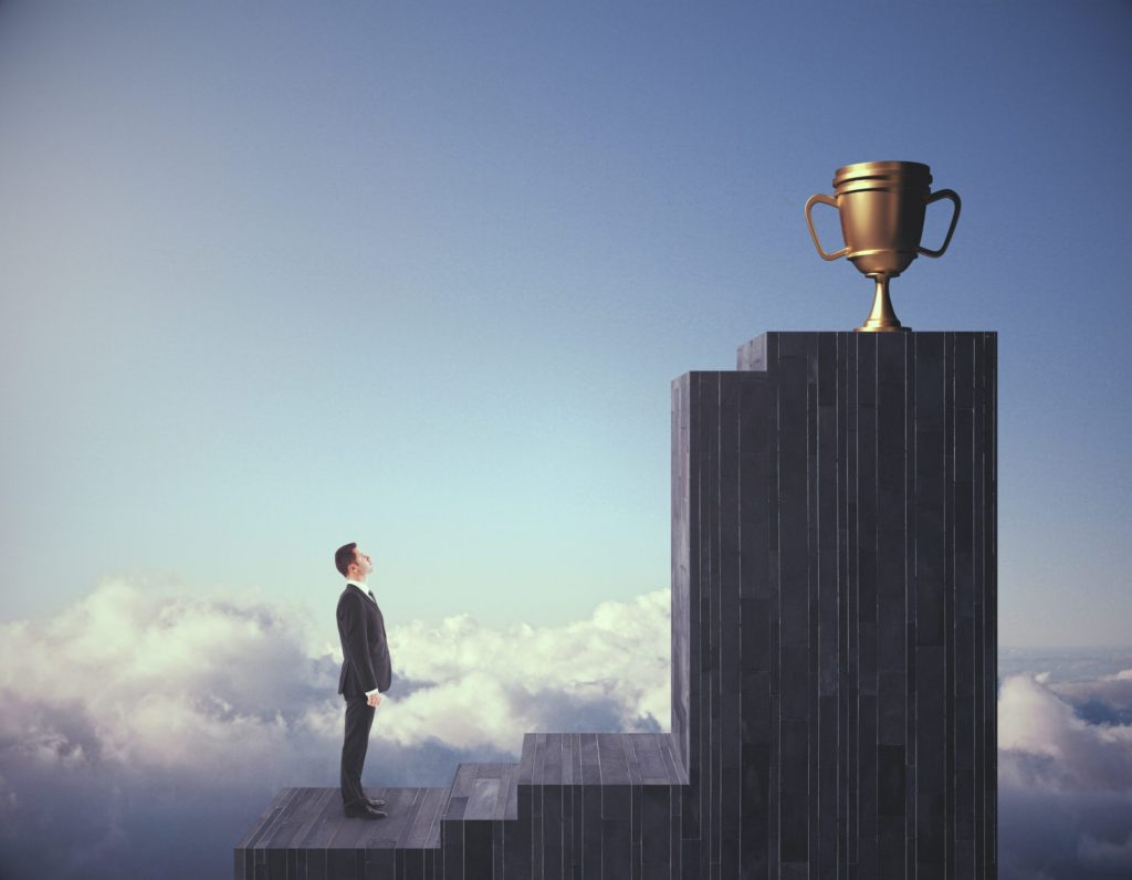 Man looking at a gold trophy on a pedestal