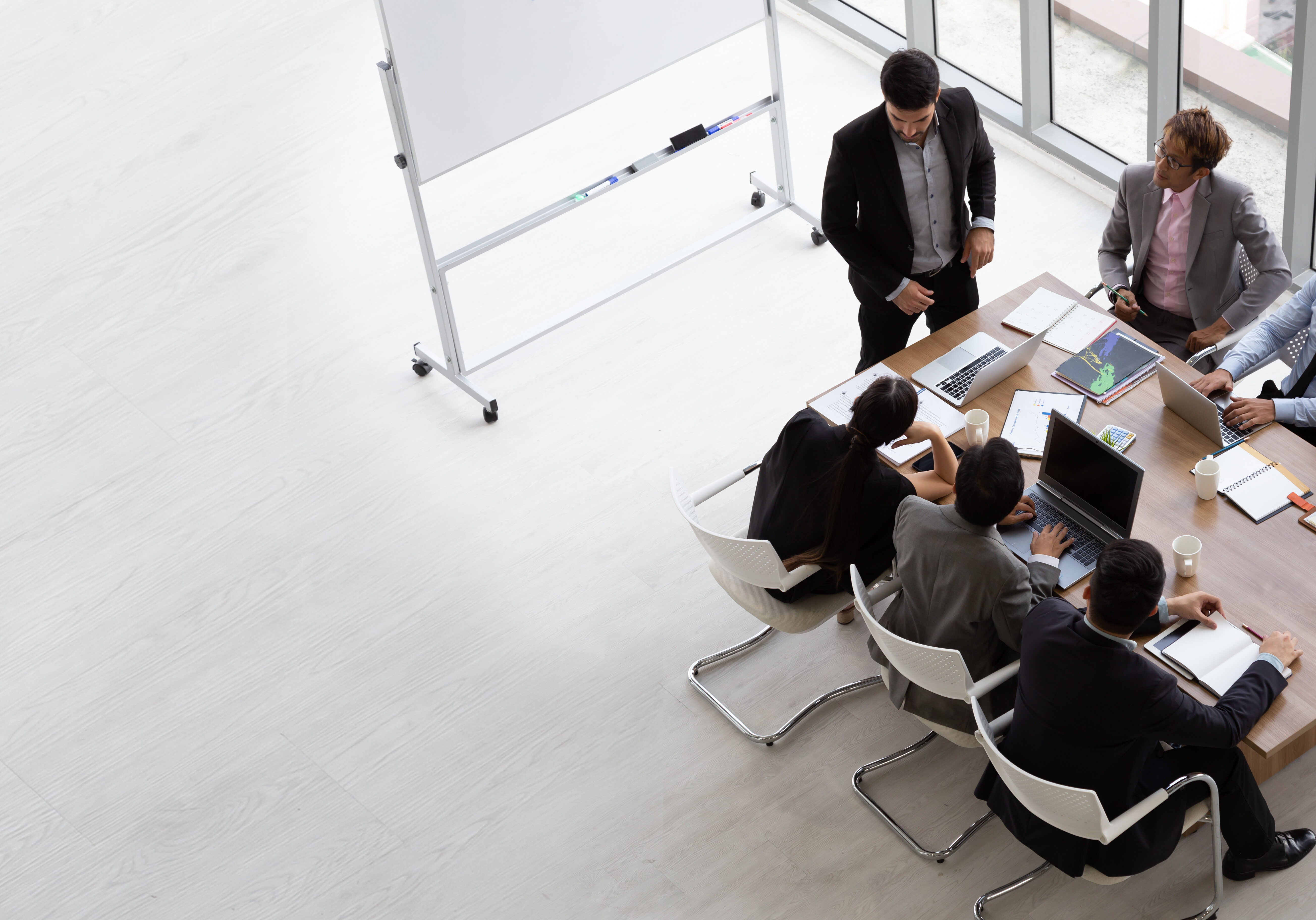 Top view of group of multiethnic busy people working in an office, Aerial view with businessman and businesswoman sitting around a conference table with blank copy space, Business meeting concept