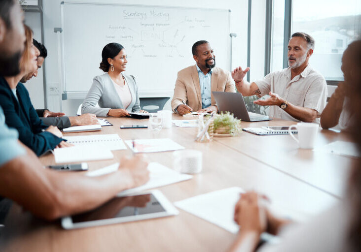 Shot of a group of staff listening to their boss during a business meeting.