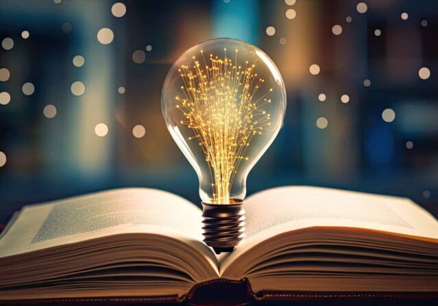 Light bulb on open book with graphs of stock market education and business growth reading for inspiration and new ideas for the future